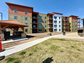Missoula apartment for rent - A modern apartment complex with a mix of tan, green, and white buildings.