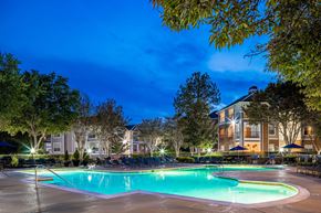 Charlotte apartment for rent - A swimming pool at a resort with trees surrounding it.