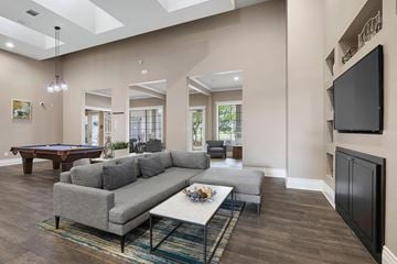 Austin apartment for rent - A living room with a grey couch and a pool table.