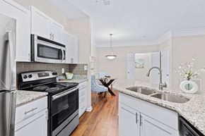Raleigh apartment for rent - A kitchen with white cabinets and a black countertop.
