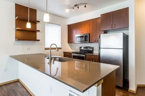 Seattle apartment for rent - A kitchen with a refrigerator, microwave, and oven.