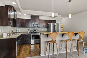 Tacoma apartment for rent - A modern kitchen with dark wood cabinets and a stainless steel refrigerator.