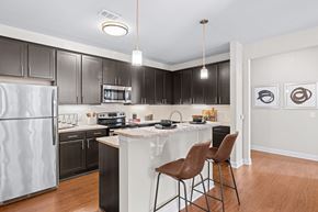 Mooresville apartment for rent - A kitchen with a white refrigerator and black cabinets.