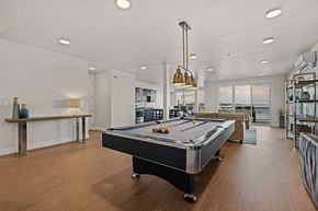 Tacoma apartment for rent - A pool table is in the middle of a room with a bar and a balcony.