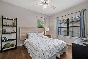 Austin apartment for rent - A bedroom with a bed, nightstand, and a ceiling fan.