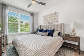 Austin apartment for rent - a bedroom with a bed and a ceiling fan