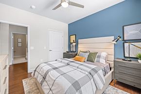 Mooresville apartment for rent - A bedroom with a bed, nightstand, and a ceiling fan.