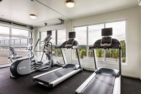 Seattle apartment for rent - A gym with treadmills, elliptical machines, and a stationary bike.