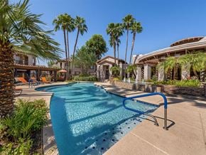Cave Creek apartment for rent - a large swimming pool with palm trees in front of a house