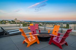 Seattle apartment for rent - a rooftop patio with orange and red chairs and a fire pit