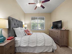 Broomfield apartment for rent - A bedroom with a bed, dresser, and ceiling fan.