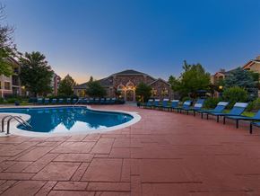Lakewood apartment for rent - a swimming pool with blue lounge chairs around it