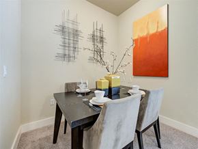 Lone Tree apartment for rent - A dining room with a table set for two and a modern abstract painting on the wall.