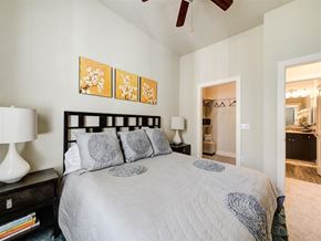 Lone Tree apartment for rent - A bedroom with a bed, a lamp, and a ceiling fan.
