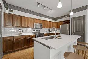 San Antonio apartment for rent - A kitchen with wooden cabinets and a white countertop.