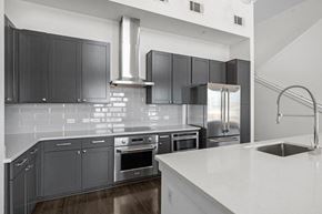 Nashville apartment for rent - A modern kitchen with dark grey cabinets and stainless steel appliances.