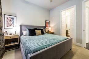 Houston apartment for rent - a bedroom with a large bed and a door to a bathroom
