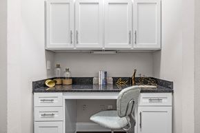 Atlanta apartment for rent - A kitchen with white cabinets and a grey chair.