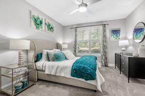 Atlanta apartment for rent - A bedroom with a bed, nightstand, and a ceiling fan.