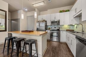 Austin apartment for rent - a kitchen with stainless steel appliances and a bar with three stools