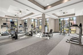 Raleigh apartment for rent - a gym with treadmills and other exercise equipment in a building with large windows