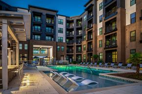 Raleigh apartment for rent - a swimming pool in front of an apartment building at night