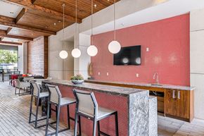 Austin apartment for rent - a kitchen with a long counter and chairs in front of a dining room