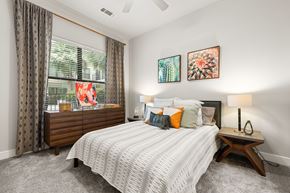 Houston apartment for rent - A bedroom with a large bed and a window with curtains.