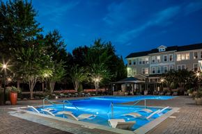 Mooresville apartment for rent - A swimming pool surrounded by trees and lights at night.