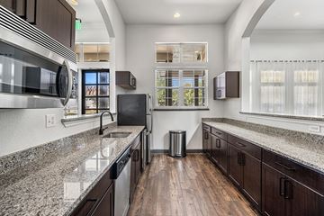 San Antonio apartment for rent - A modern kitchen with dark wood cabinets and granite countertops.
