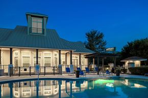 San Antonio apartment for rent - a swimming pool with chairs and a building in the background