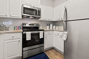 Atlanta apartment for rent - A kitchen with white cabinets and a stainless steel refrigerator.
