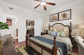 Rockwall apartment for rent - A bedroom with a large bed and a ceiling fan.