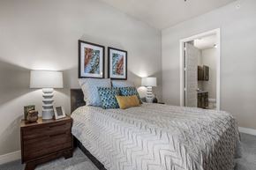 Austin apartment for rent - A bedroom with a bed, nightstand, and two wall lamps.