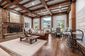 Flower Mound apartment for rent - A living room with a stone fireplace and wooden floors.