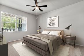 Frisco apartment for rent - A bedroom with a bed, a ceiling fan, and a window with blinds.