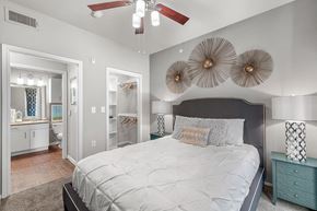 Dallas apartment for rent - A bedroom with a large bed and a ceiling fan.