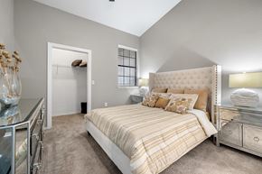 Richardson apartment for rent - A bedroom with a bed, nightstand, and a dresser with a mirror.