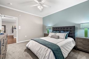 Tyler apartment for rent - A bedroom with a large bed and a ceiling fan.