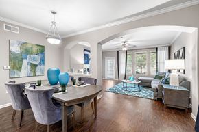 Tyler apartment for rent - A dining room with a table set for two and a couch in the background.