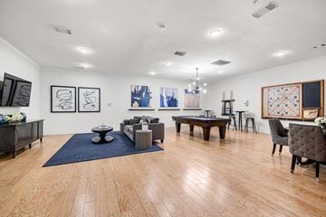 Tyler apartment for rent - A living room with a blue rug and wooden floors.