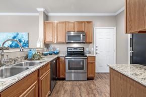 Tyler apartment for rent - A kitchen with wooden cabinets and stainless steel appliances.