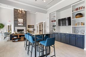 Charlotte apartment for rent - A modern kitchen with blue chairs and a fireplace.