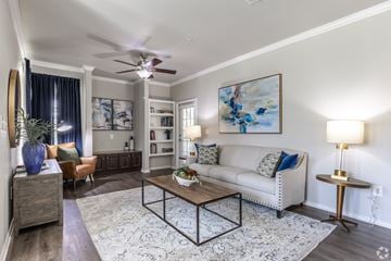 Fort Worth apartment for rent - A living room with a white couch, a coffee table, and a painting on the wall.