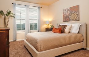 San Antonio apartment for rent - A bedroom with a large bed and a painting on the wall.
