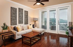 San Antonio apartment for rent - A living room with a white couch, a wooden coffee table, and a ceiling fan.