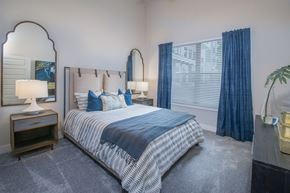 San Antonio apartment for rent - A bedroom with a bed, nightstand, and a mirror.