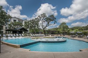 San Antonio apartment for rent - A large outdoor swimming pool with a hot tub and lounge chairs.