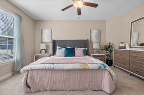 Durham apartment for rent - A bedroom with a bed, dresser, and ceiling fan.