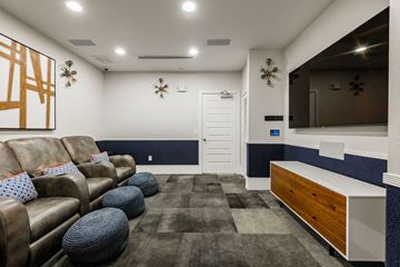 Katy apartment for rent - A living room with brown leather couches and a blue and white accent wall.